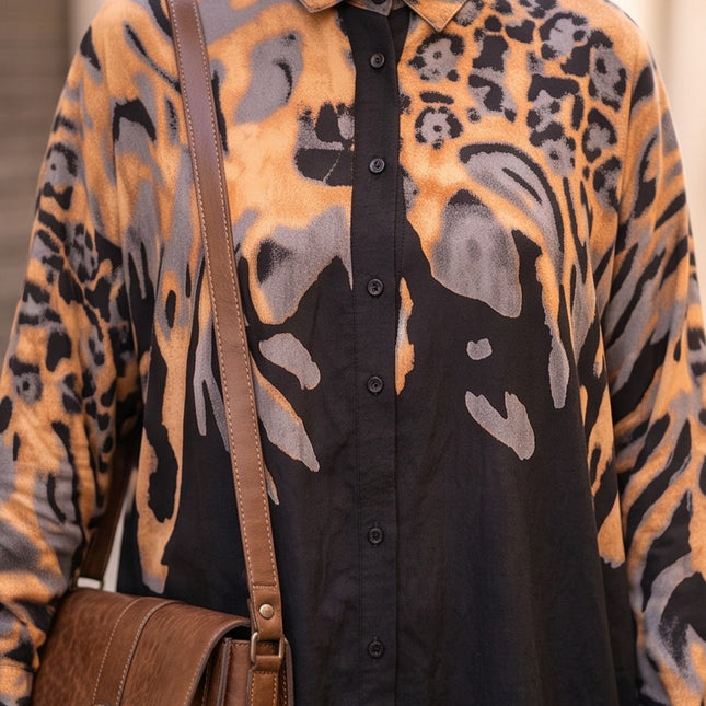 Brand Zee long sleeve button-down shirt in black, ochre, and grey animal print worn with a brown crossbody bag
