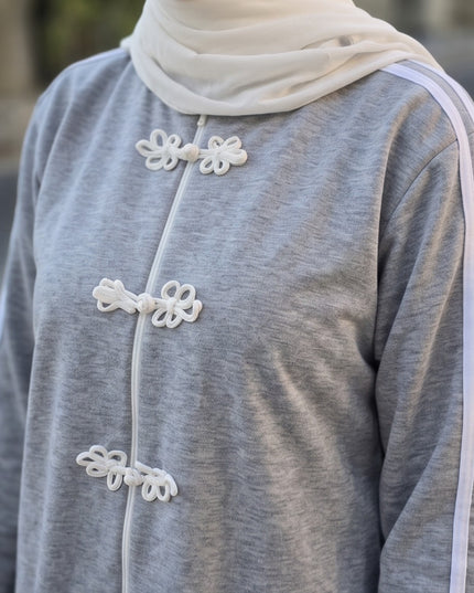 Brand Zee grey sporty tracksuit top with white decorative knot fastenings, zip closure, and side sleeve stripes.