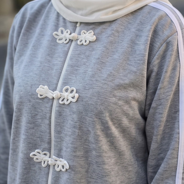 Brand Zee grey sporty tracksuit top with white decorative knot fastenings, zip closure, and side sleeve stripes.