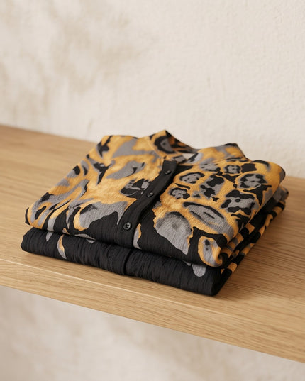 Brand Zee folded two-piece co-ord set featuring an abstract animal print in ochre, charcoal, and black on a shelf.
