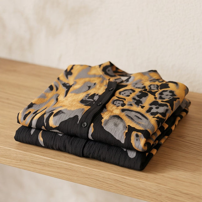 Brand Zee folded two-piece co-ord set featuring an abstract animal print in ochre, charcoal, and black on a shelf.