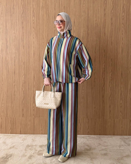 Brand Zee striped two-piece set with a zip-up top and wide-leg trousers, worn with a beige hijab and matching handbag.